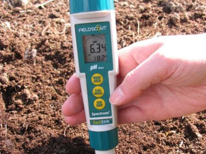 Soil moisture sensor probe measuring root zone development in a crop field